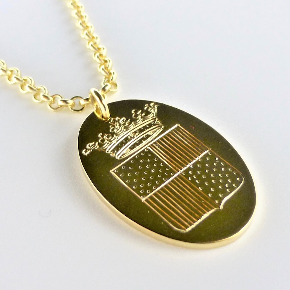 Gold oval pendant engraved family crest