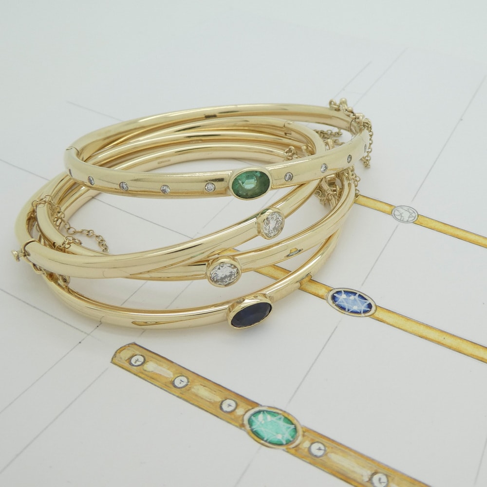 Yellow gold diamond emerald and sapphire set bangles