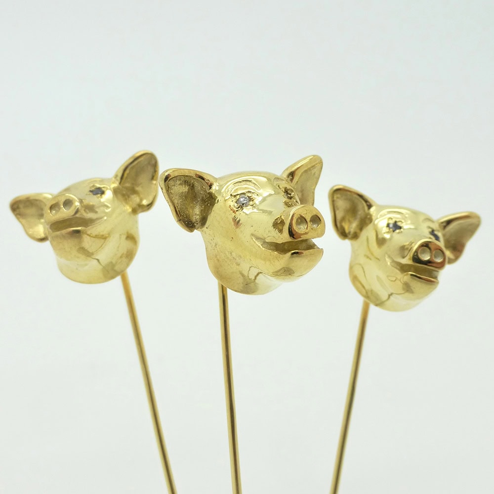 Bespoke pig head 9 carat gold tie pins. Diamond set eyes for the groom, sapphires for the best men