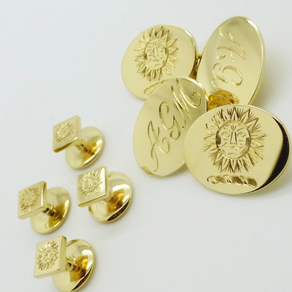 Traditional gold oval double ended cufflinks with a set of dress shirt studs all hand engraved with family crest
