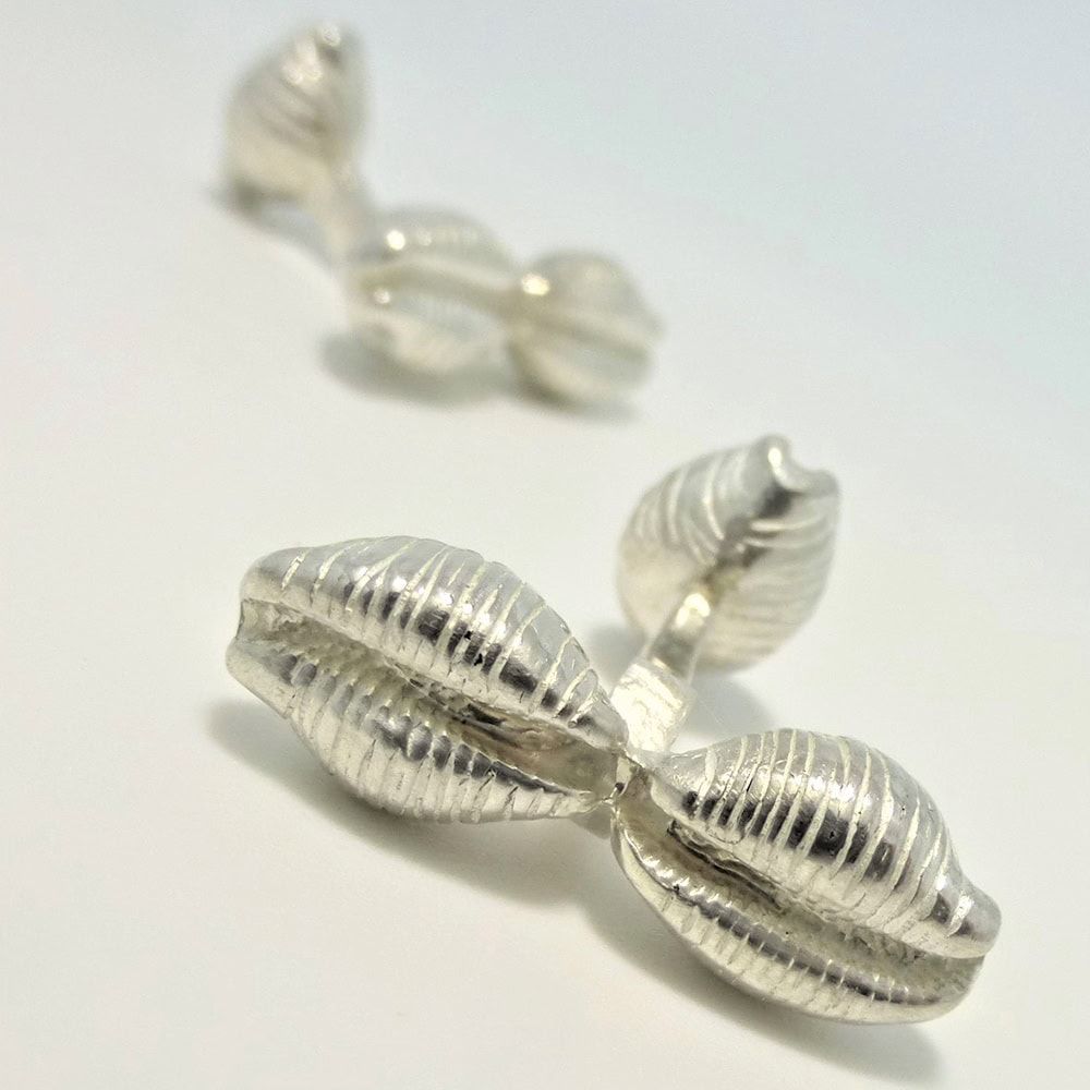 Using a real cowrie shell collected by the customer as a pattern taking a mould casting into silver to create bespoke cowrie cufflinks